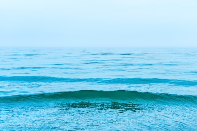 Agua de mar azul con olas y nubes blancas en el cielo. Tranquilo paisaje tropical