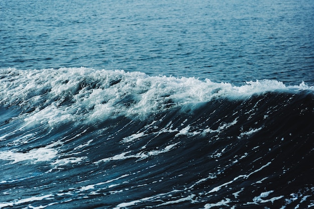 Agua de mar azul con onda blanca de fondo.