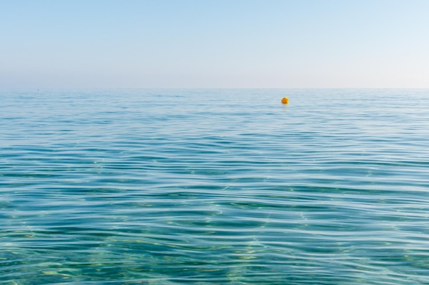 Agua de mar con boya marcadora amarilla