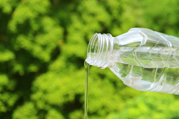 Agua mineral que fluye de una botella de plástico.