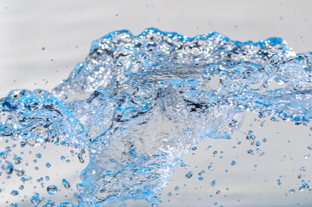 Agua en movimiento con gotas en estudio con fondo blanco Spash