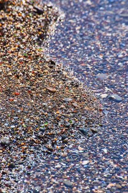 Foto Água na costa da praia de vidro coberta de pedaços de vidro