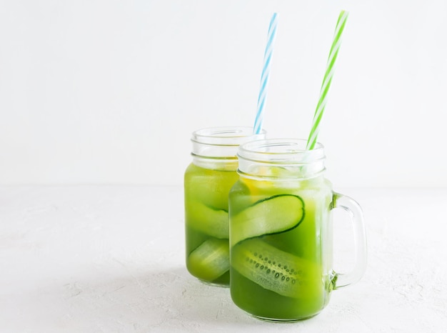 Agua de pepino con albahaca y limón en una taza de vidrio sobre la mesa