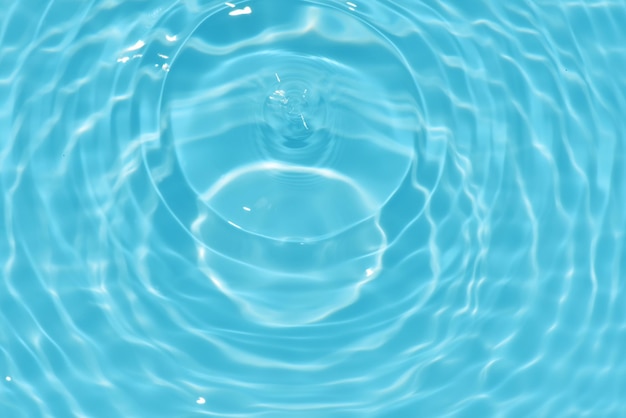 Agua en una piscina azul con una gota de agua