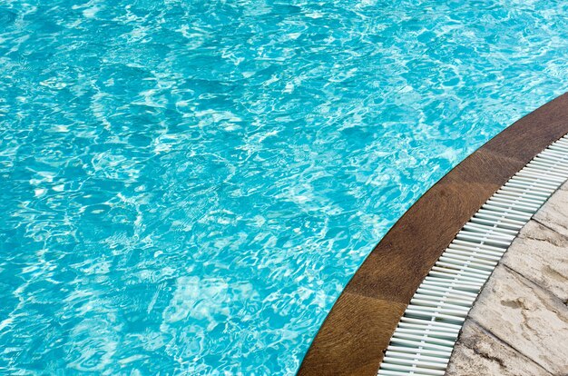 El agua de la piscina azul con reflejos del sol