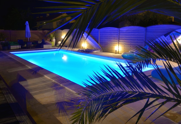 Agua de piscina iluminada en azul por noche.