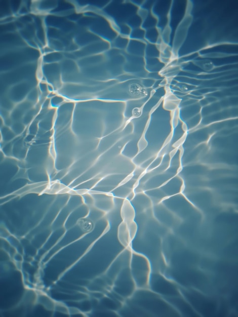 Agua en una piscina con el sol brillando sobre el agua