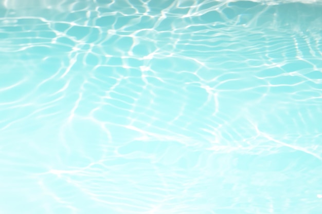 Agua en una piscina con el sol reflejado en la superficie del agua.