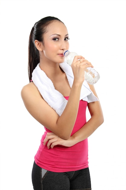 Agua potable asiática atractiva de la mujer sonriente