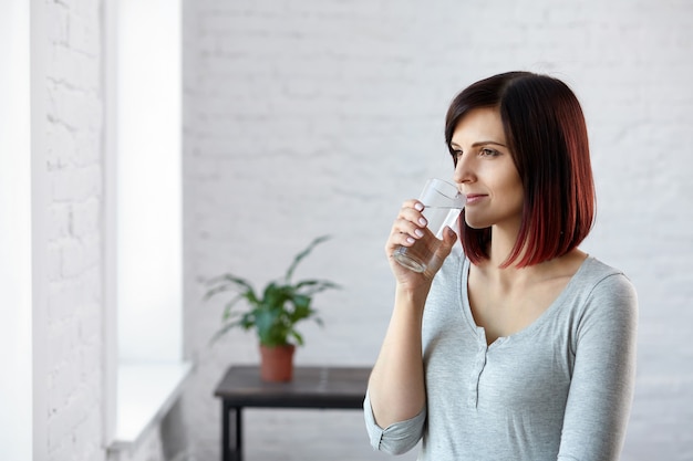 Agua potable. Estilo de vida saludable. Concepto de dieta. Alimentación saludable. Hermosa mujer joven agua potable.