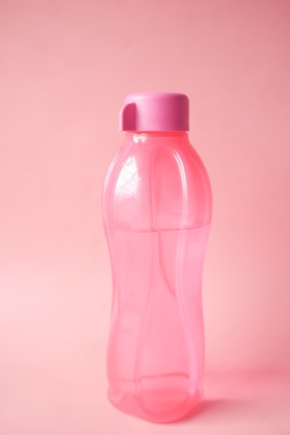 Agua potable fresca en una botella de color rosa