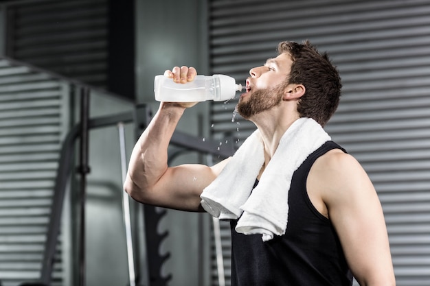 Agua potable del hombre apto en el gimnasio de crossfit