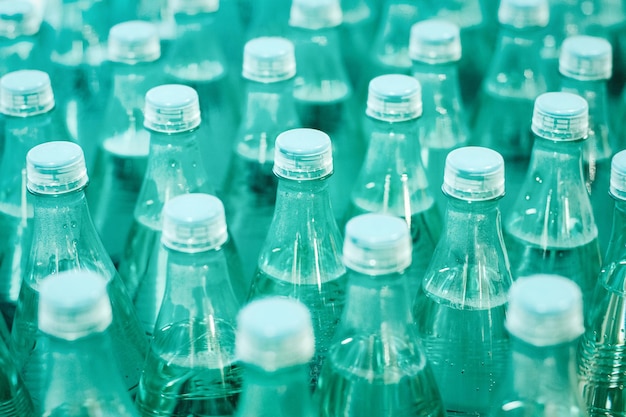 Agua potable mineral en botellas de plástico verde en la tienda de comestibles