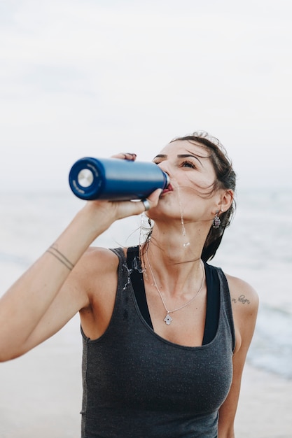 Agua potable de mujer después de un entrenamiento