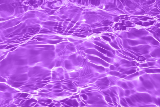 Agua púrpura con ondas en la superficie Desenfoque borroso transparente de color azul claro agua tranquila