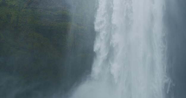 Agua que cae de la cascada épica de Skogafoss en Islandia