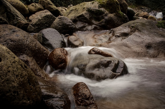 El agua que cae en el lago rodeado por las rocas en los baños de Afrodita en Georgia