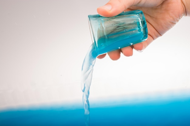 El agua que desemboca del vaso en la mano