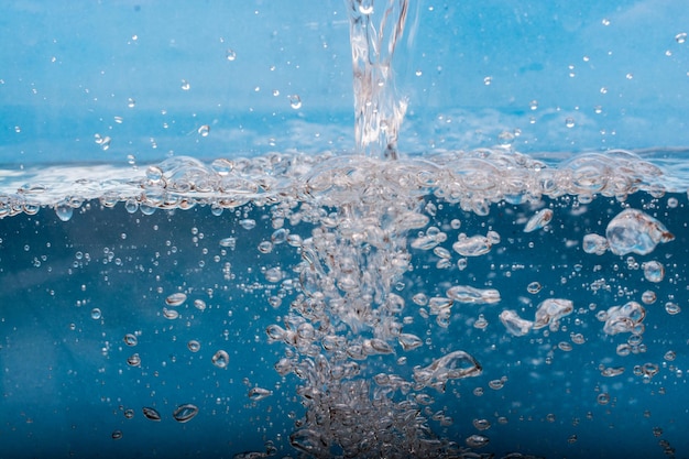 El agua que fluye causa muchas burbujas en el agua bajo el agua