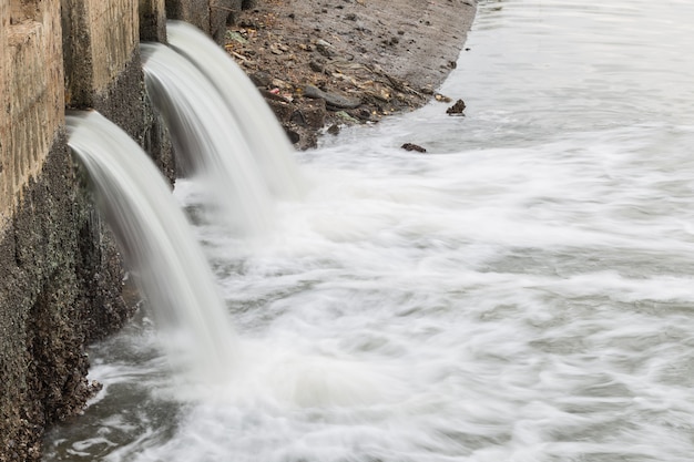 El agua que fluye del desagüe al río