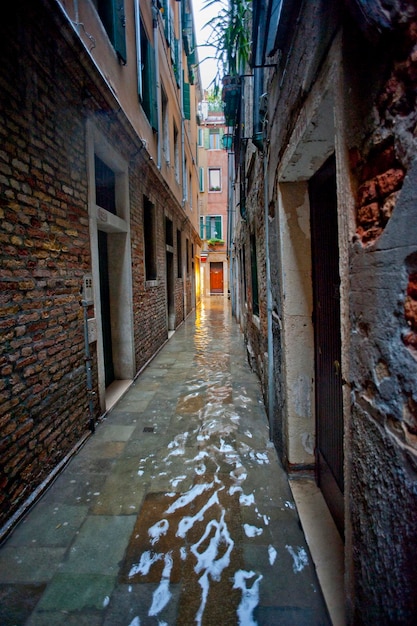 Foto agua recogida en el callejón entre los edificios durante la temporada de lluvias