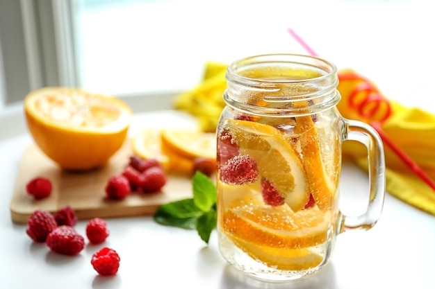 Agua refrescante con frutas en la mesa