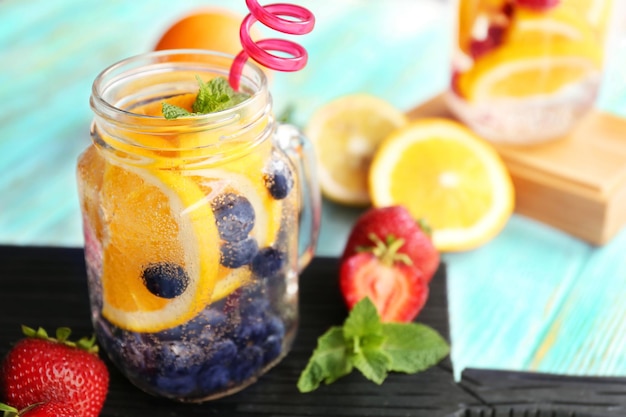 Agua refrescante con frutas en la mesa