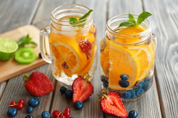 Agua refrescante con frutas en la mesa