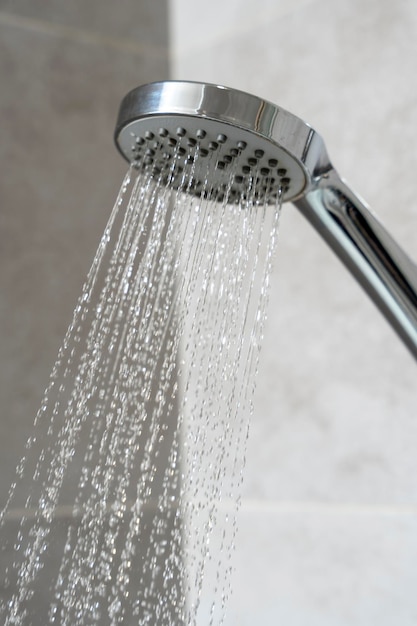 El agua sale del baño de ducha con cabezal de ducha Cerrar