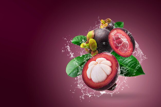 Foto el agua salpicando en mangosteens reina de las frutas sobre fondo rojo