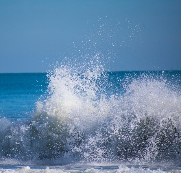 Foto el agua salpicando en el mar contra el cielo despejado