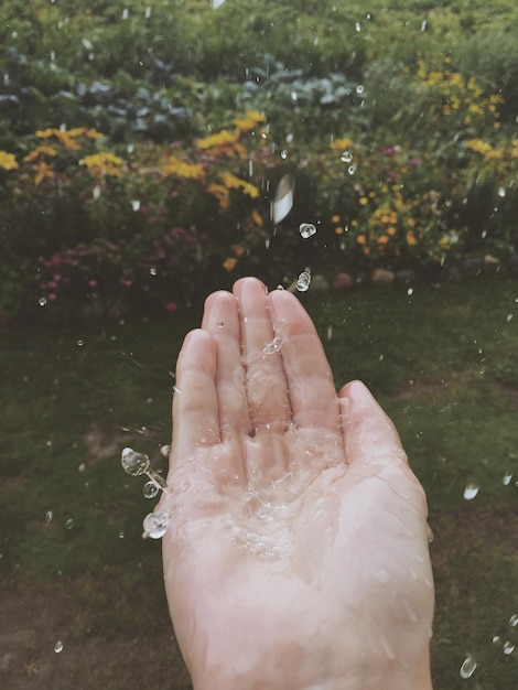 Foto el agua salpicando en la palma contra el campo