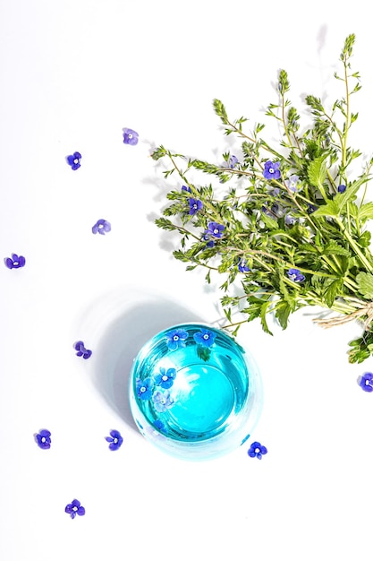 Agua tónica fría y azul no me olvides ramo de flores en un stand de moda aislado en fondo blanco