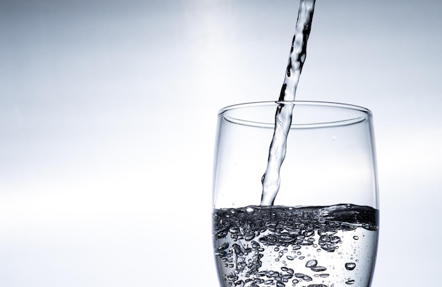 El agua se vierte en un vaso desde arriba