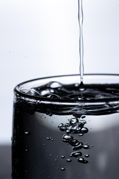 El agua se vierte en un vaso desde arriba