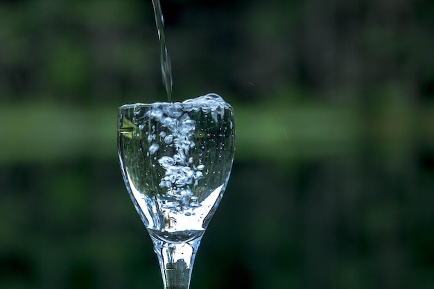 El agua se vierte en el vaso de vino.