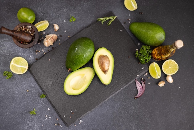 Aguacado verde en la tabla de servicio de piedra