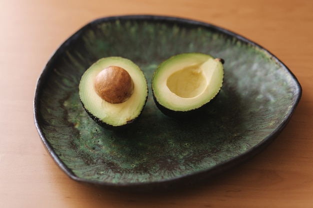 Aguacate fresco en rodajas en placa verde. Concepto de comida vegetariana