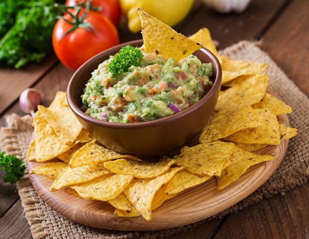 Aguacate guacamole, lima, tomate, cebolla y cilantro, servido con nachos - Merienda tradicional mexicana