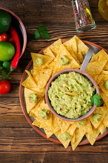 Aguacate guacamole, lima, tomate, cebolla y cilantro, servido con nachos