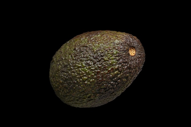 Un aguacate maduro sobre fondo negro