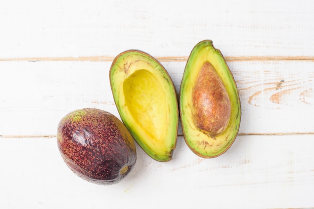 Aguacate en mesa de madera blanca