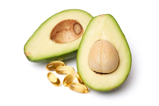 Aguacate orgánico fresco partido a la mitad y cápsulas con Omega-3 aislado