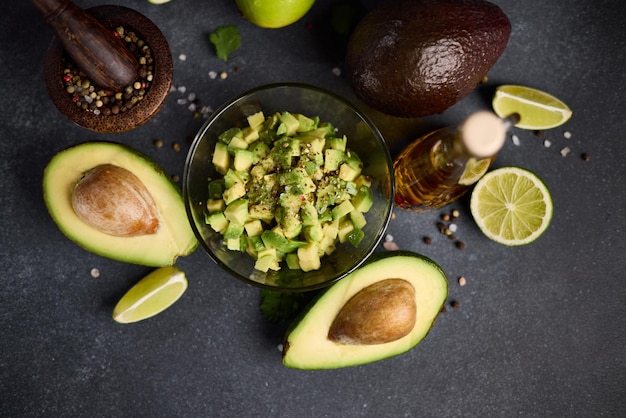 Foto aguacate picado en un cuenco de vidrio y mitades de aguacate