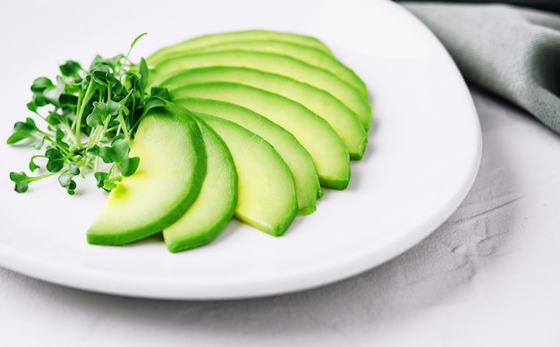 Aguacate en rodajas en un plato blanco