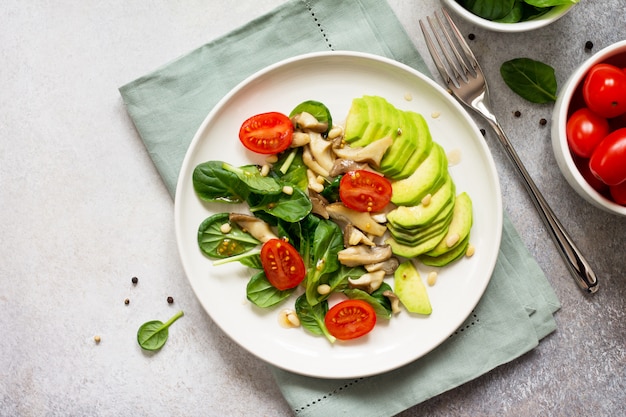 Aguacate con tomates y espinacas en un plato