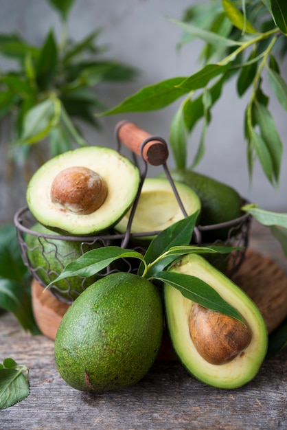 Foto aguacate verde fresco con hojas en el espacio de madera