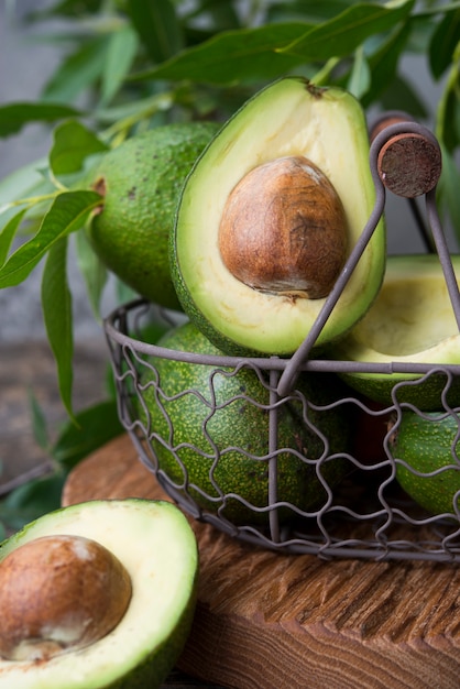 Aguacate verde fresco con hojas en el espacio de madera