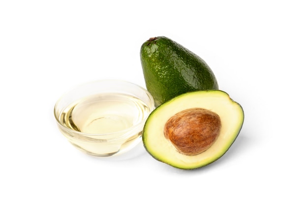 Aguacates frescos con aceite sobre un fondo blanco.