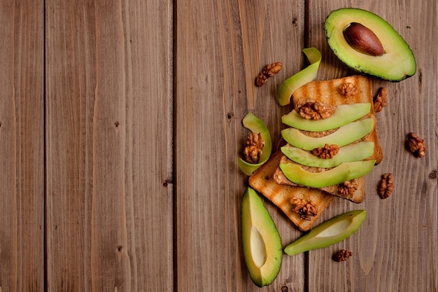 Aguacates y tostadoras con pasta de maní en madera